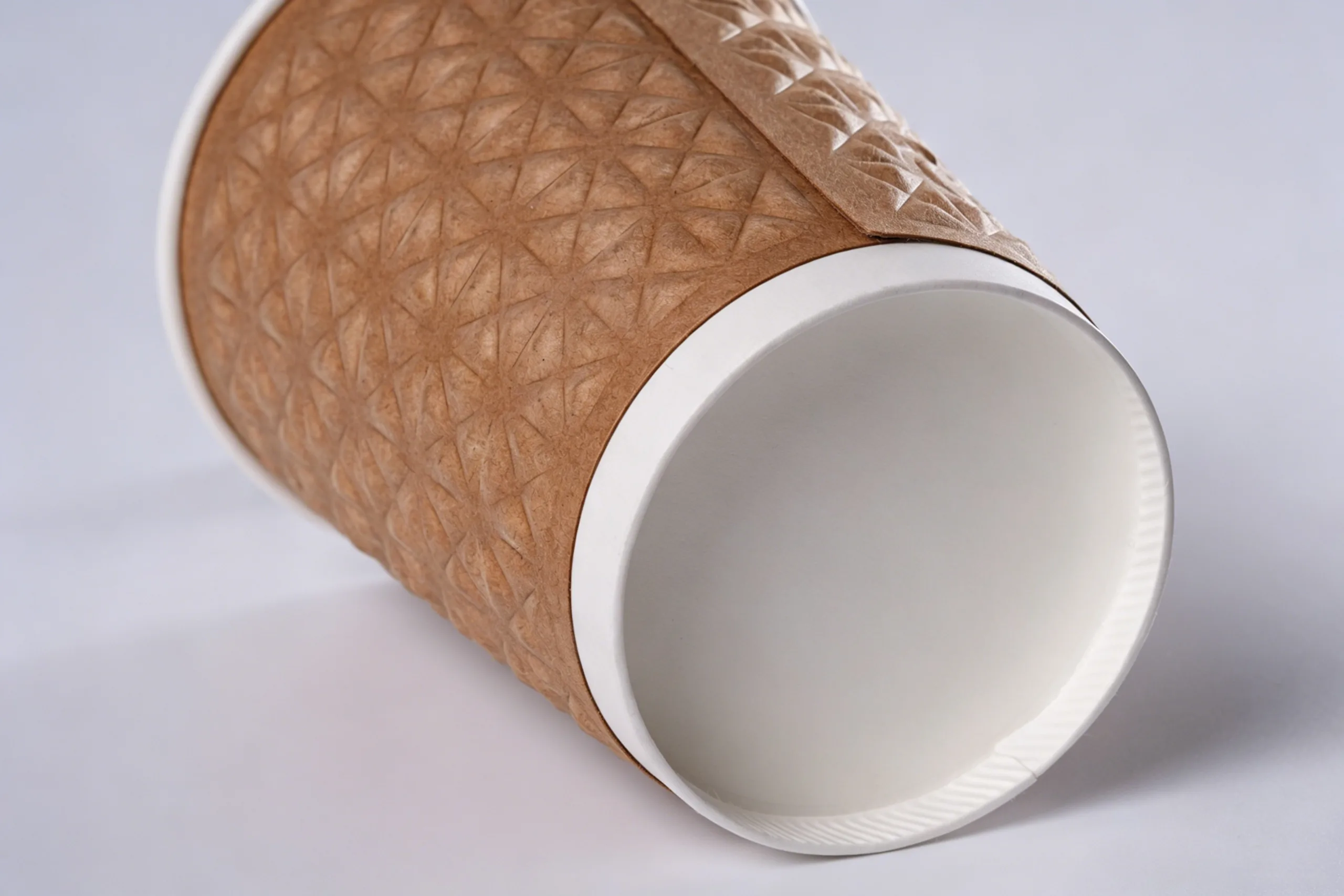Macro close-up: deep diamond embossing on kraft paper cup – texture depth